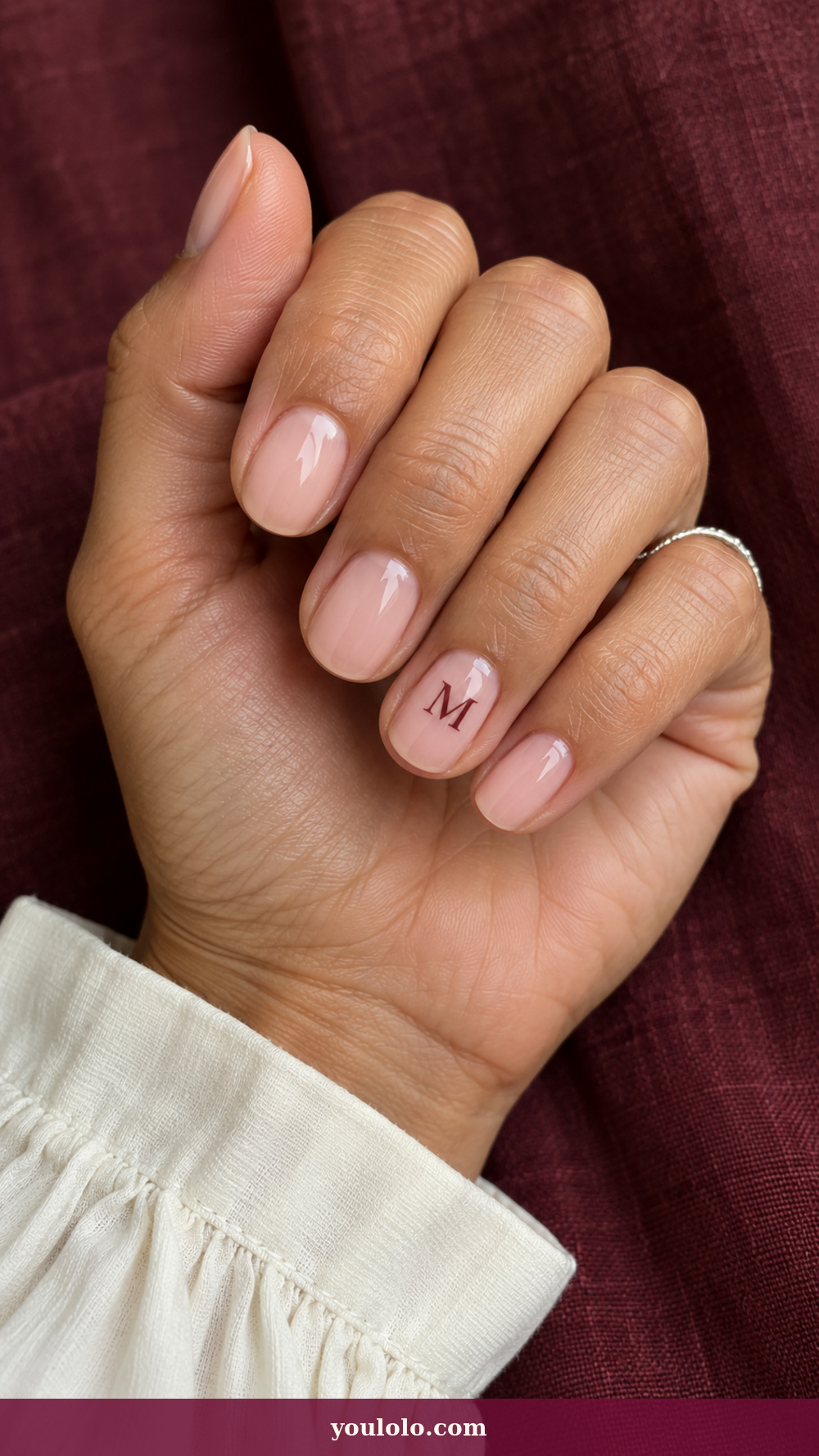 Initial Nails idea 1: Burgundy Serif Monogram on a realistic feminine hand