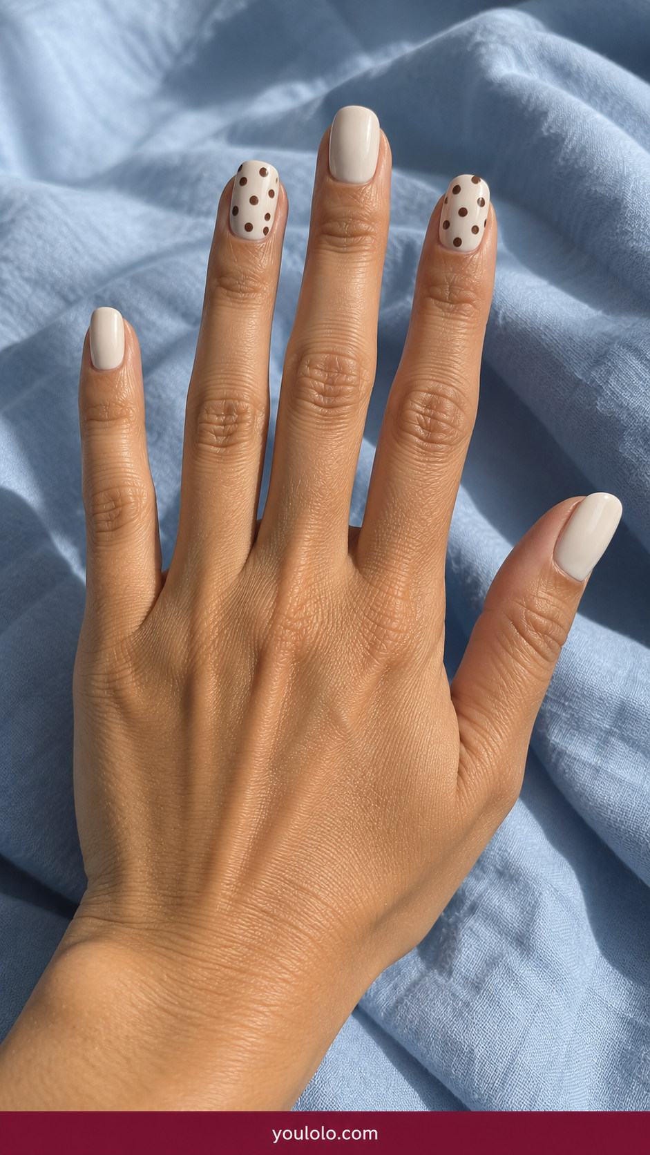 Polka Dot Nails idea 2: cream squoval nails with chocolate-brown polka dots concentrated on two accent nails on an anatomically realistic feminine hand