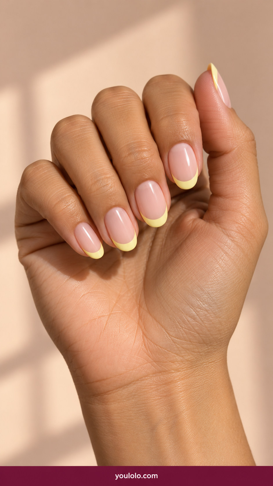 Butter Yellow Nails idea 3: butter-yellow French tips over a nude pink nail base on an anatomically realistic feminine hand