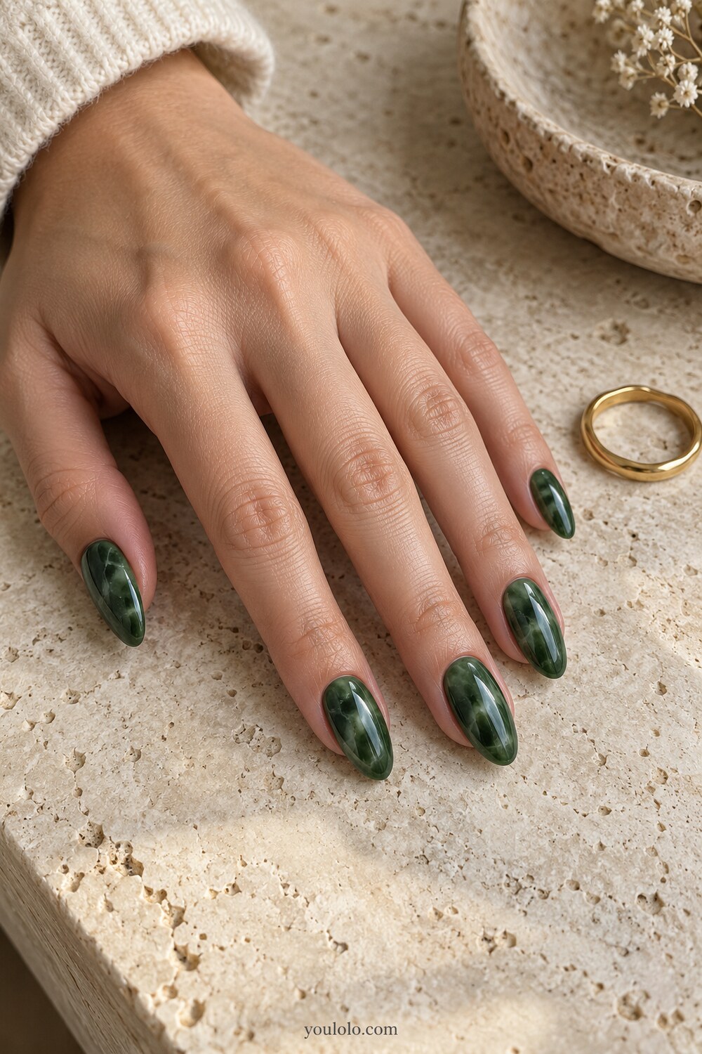 Deep emerald stone manicure with restrained gold foil