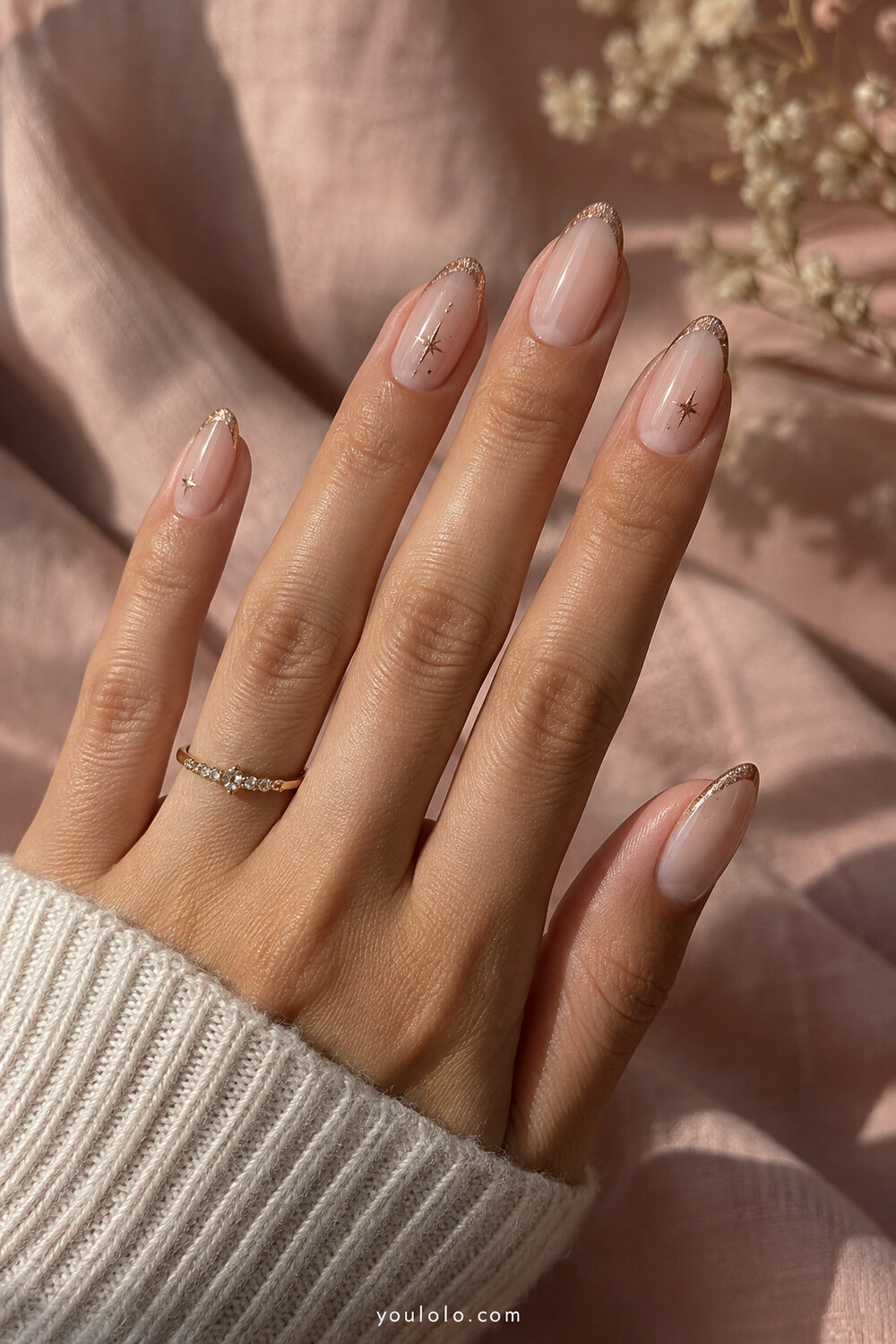Nude almond nails with rose gold micro French tips and fine stars