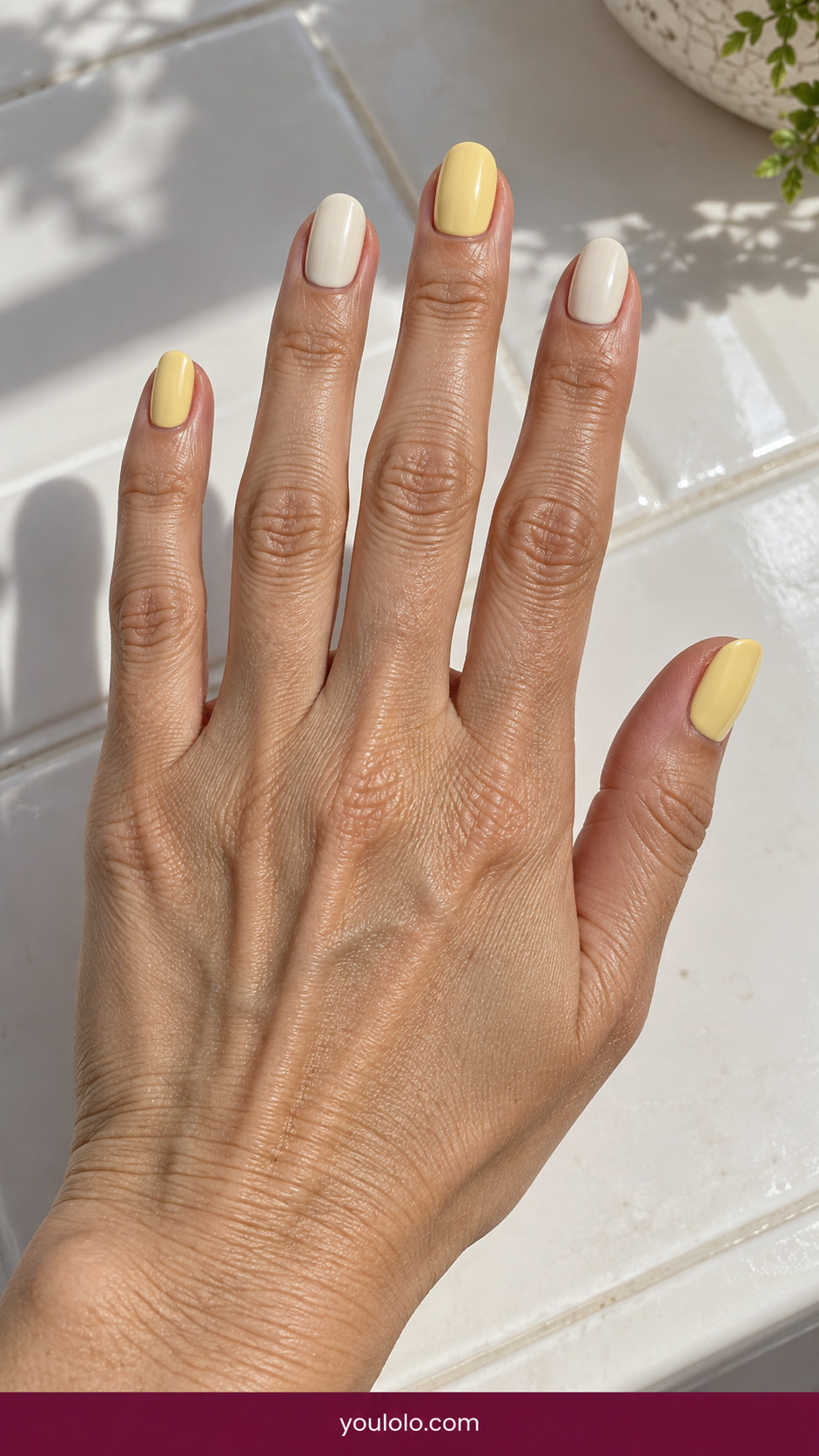 Butter Yellow Nails idea 5: butter-yellow and warm cream alternating solid nails on an anatomically realistic feminine hand