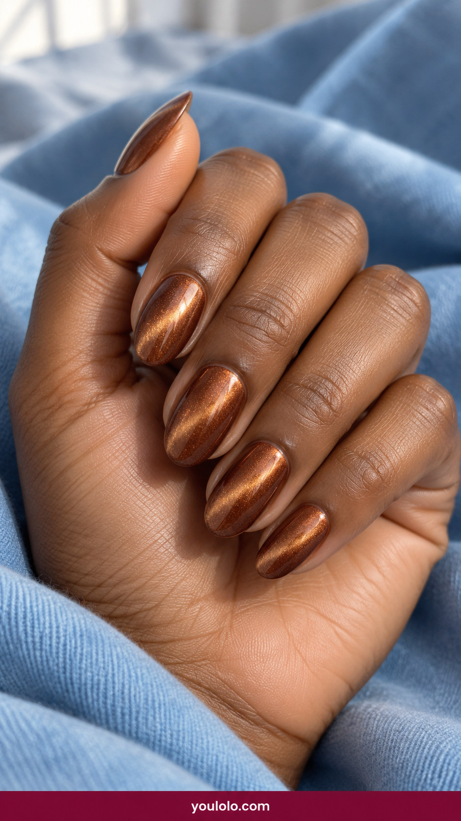 Cat Eye Nails idea 5: copper bronze magnetic cat-eye with warm golden shimmer drawn toward one side on an anatomically realistic feminine hand