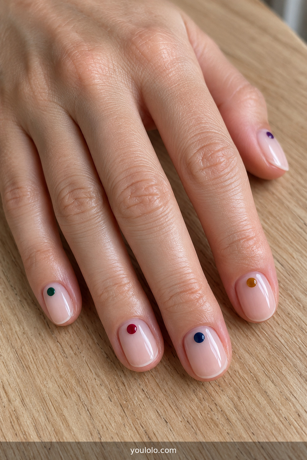 Minimal manicure with tiny jewel-tone dots near each cuticle