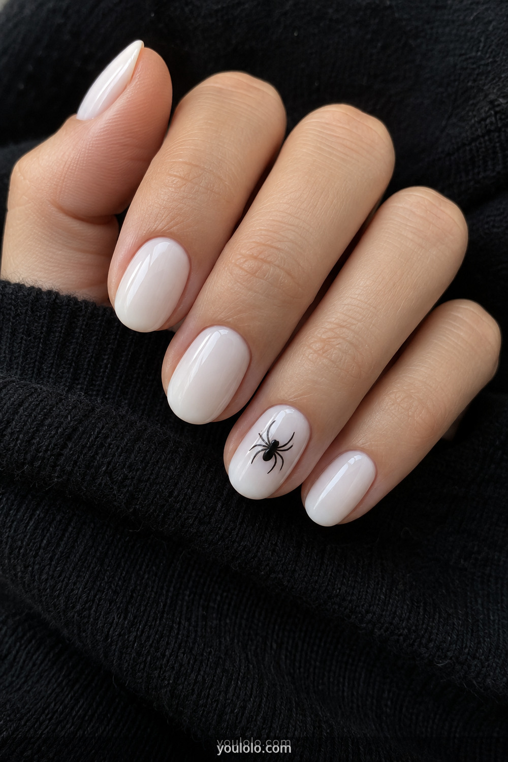 White manicure with one simple black spider accent nail