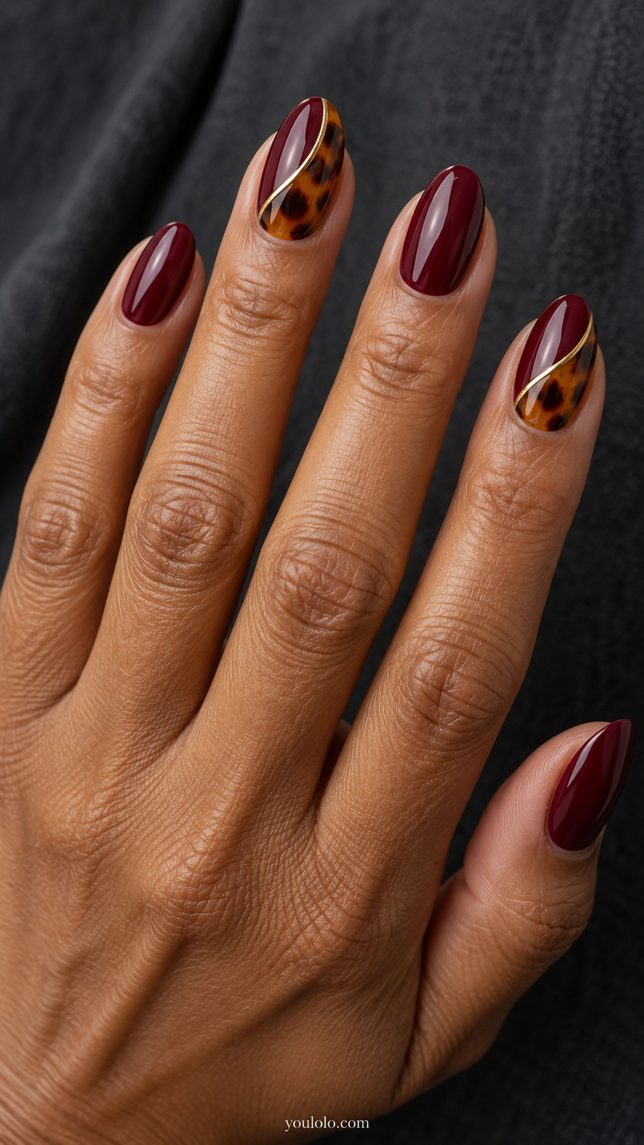 A fine gold border between wine and amber manicure
