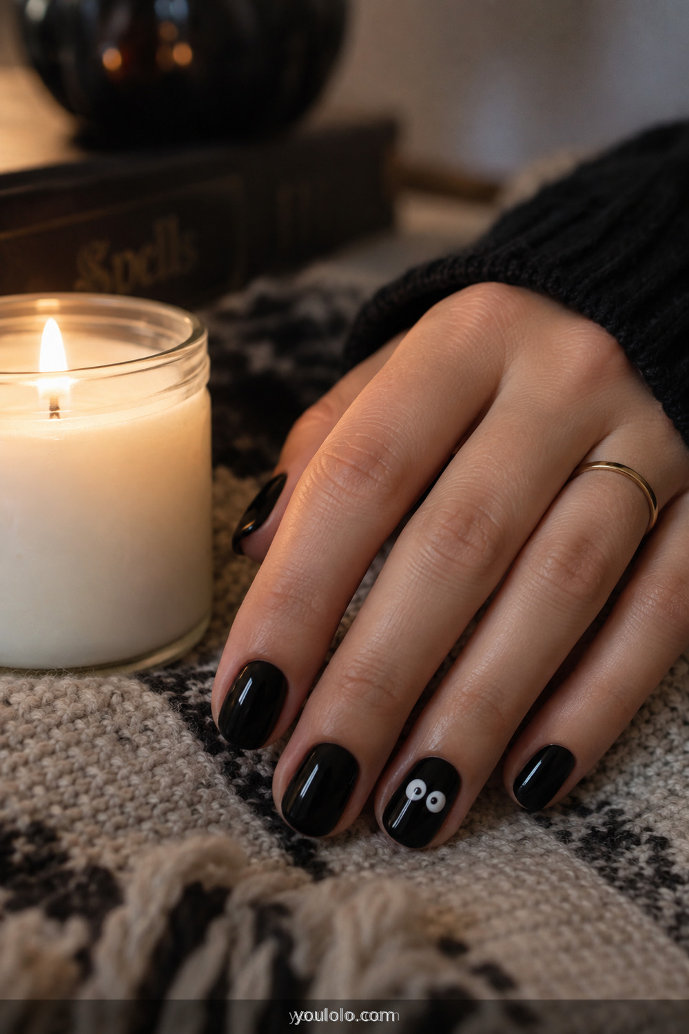 Black nails with tiny white spooky eyes made using a dotting tool
