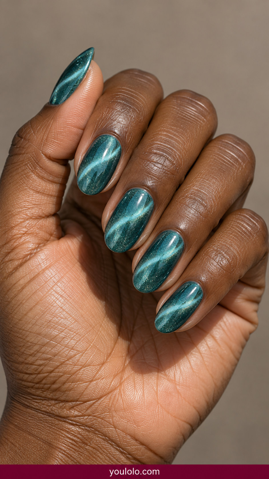 Cat Eye Nails idea 8: sea-glass teal magnetic cat-eye with subtle pale aqua crescent stripe on an anatomically realistic feminine hand