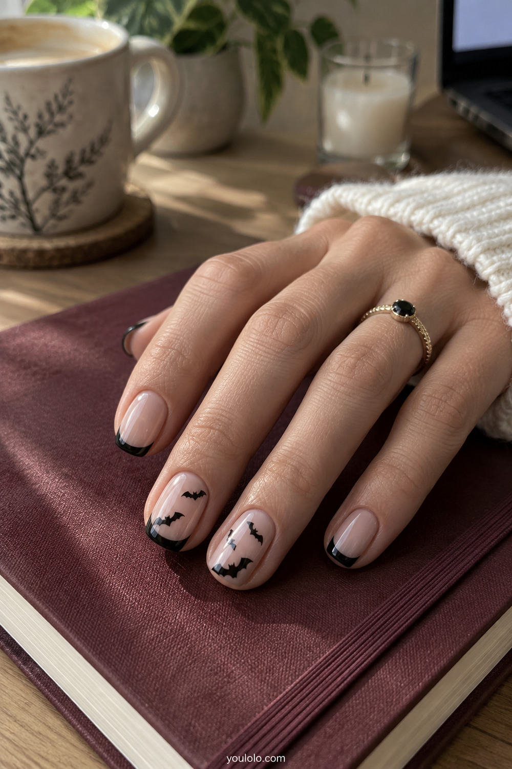 Tiny black bat nail art over a blush base and short French tips