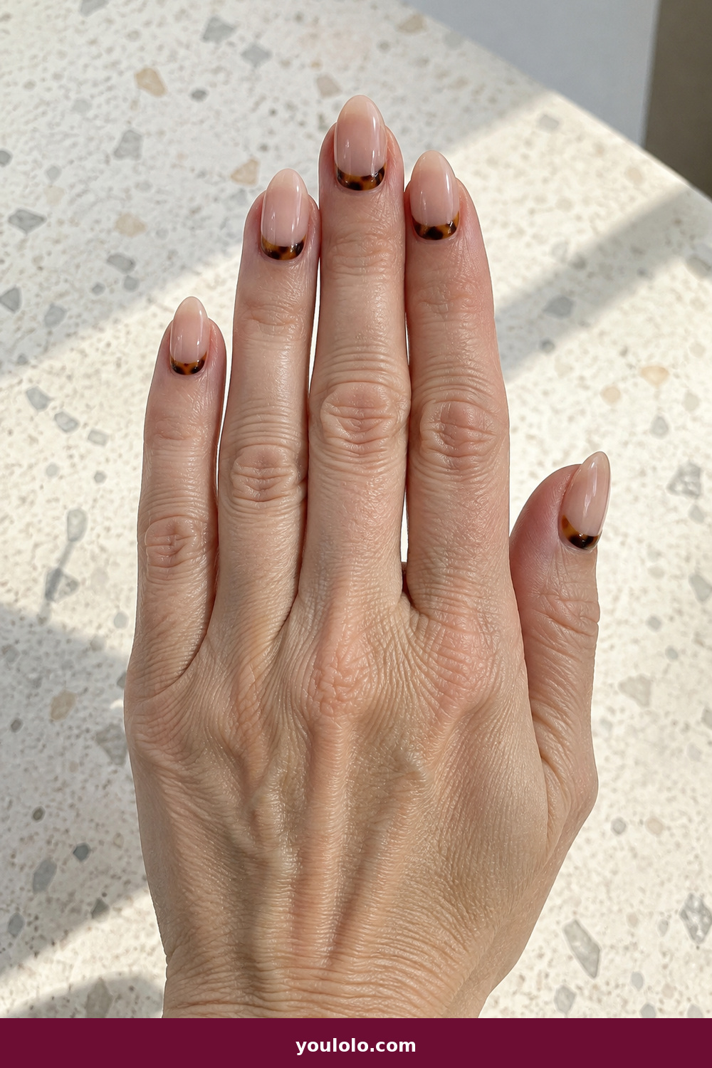 Elegant Almond Nails idea 9: Tortoise Crescent, medium almond sheer nude nails with small tortoiseshell crescents at the base