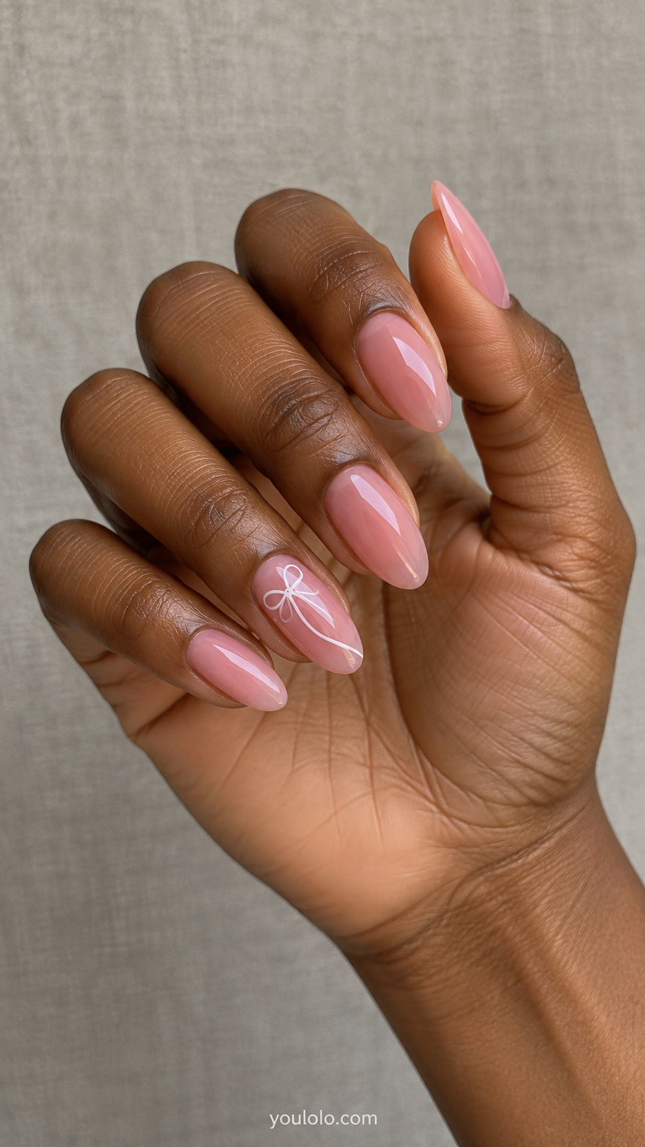 Pink glaze with a fine white ribbon bow manicure