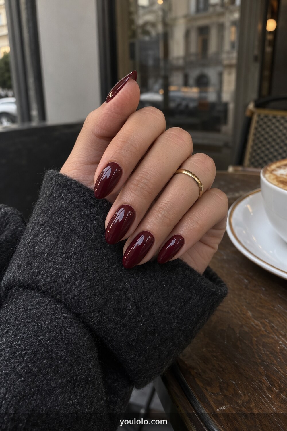Deep burgundy polish on elegant almond nails