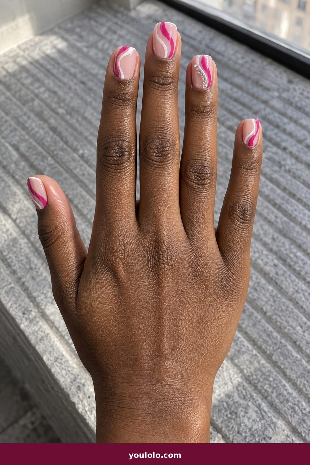 Pink Nails with Rhinestones on One Finger Ideas: Negative-Space Crystal Wave, Short nude-pink nails with fuchsia and white negative-space waves, traced by four tiny crystals on the ring finger.