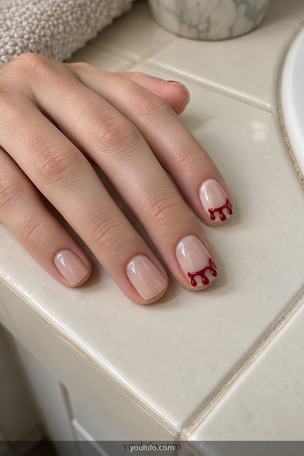 Nude nails with simple glossy red Halloween drip tips