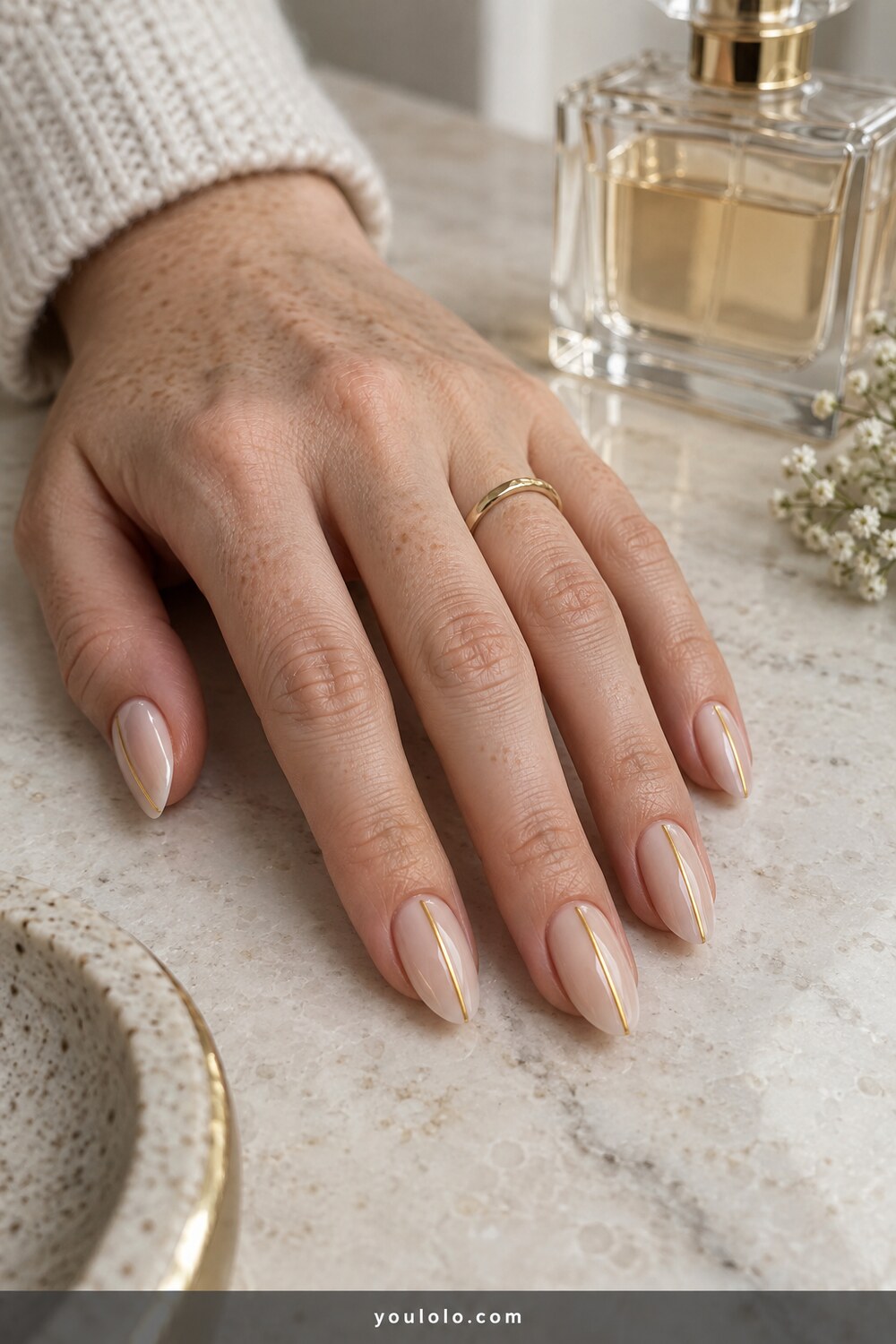 Minimal nude almond nails with a fine gold vertical line