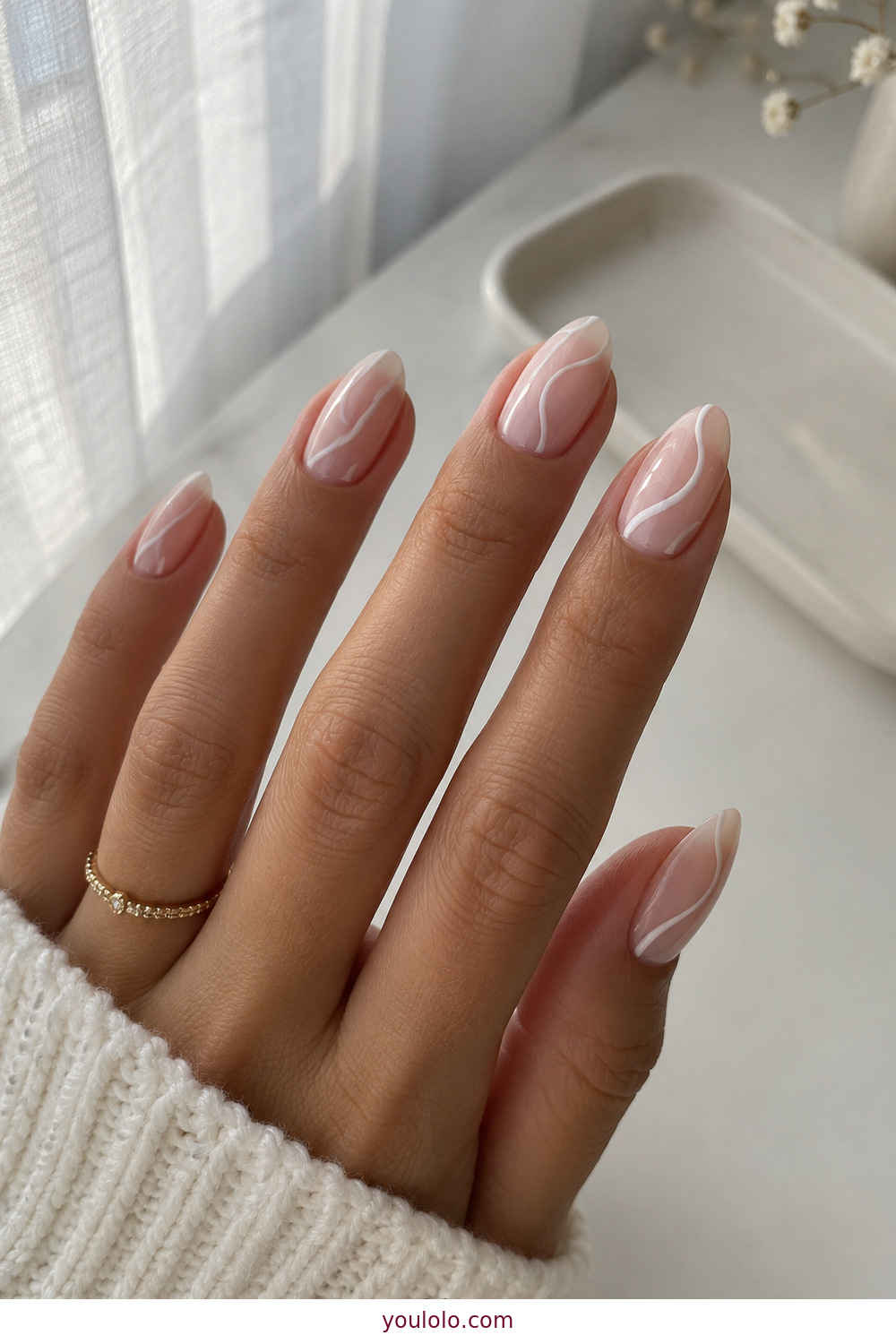 Soft white swirl nail art over a sheer milky base
