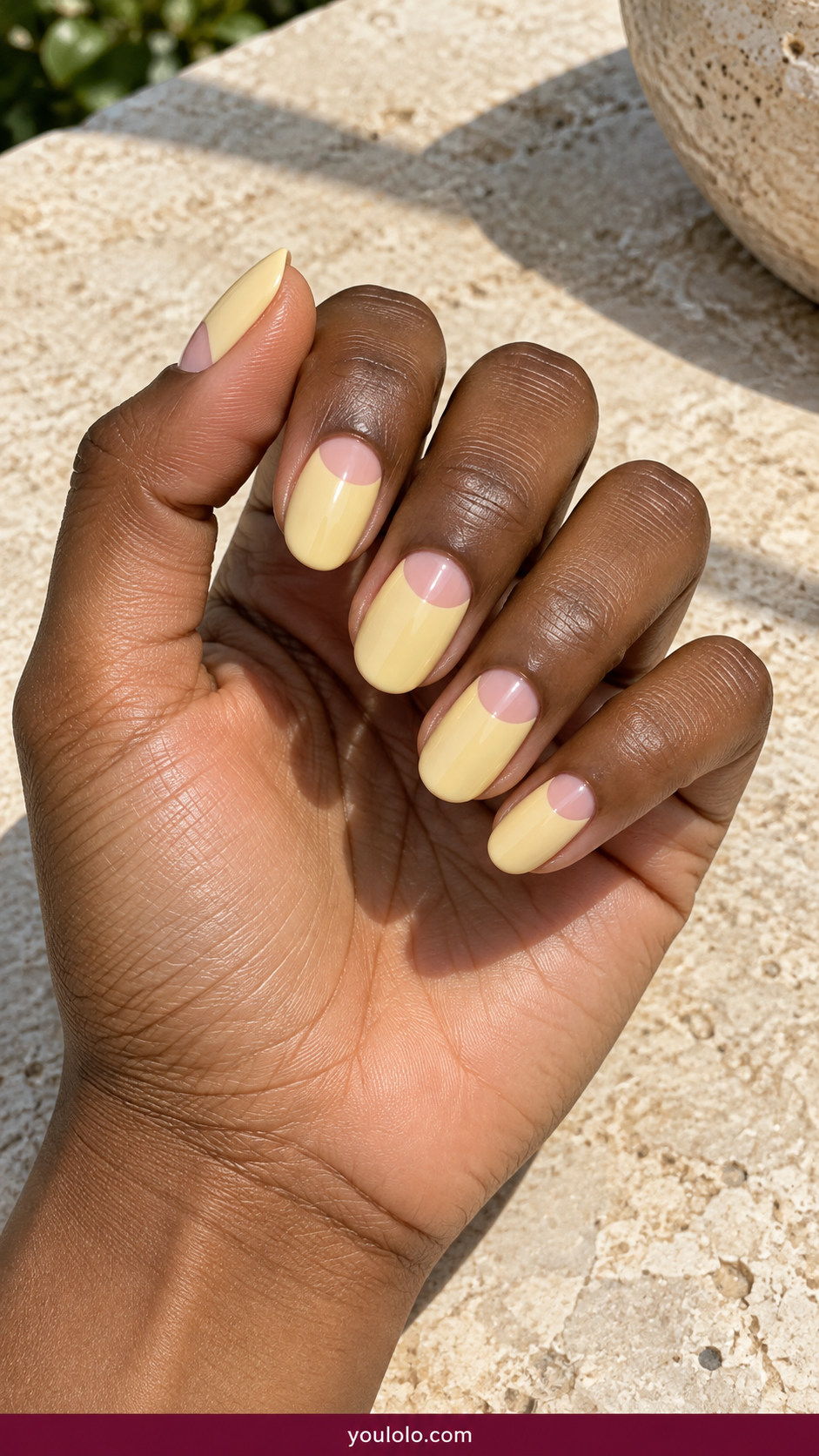 Butter Yellow Nails idea 13: butter-yellow and blush pink small half-moon design on an anatomically realistic feminine hand