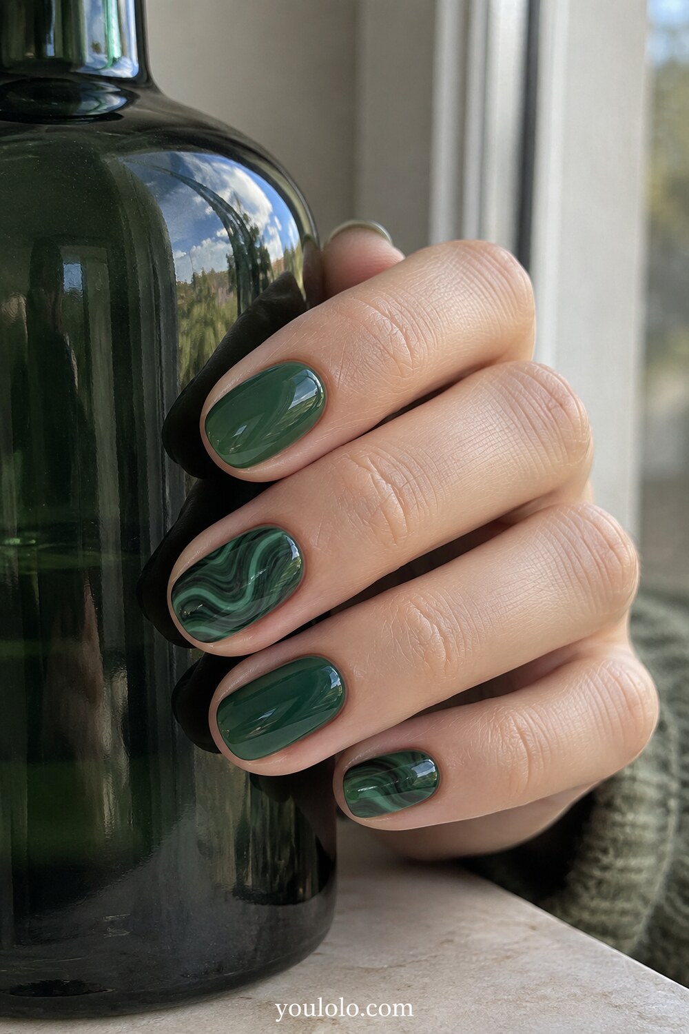 Bottle green manicure with delicate asymmetric gold lines