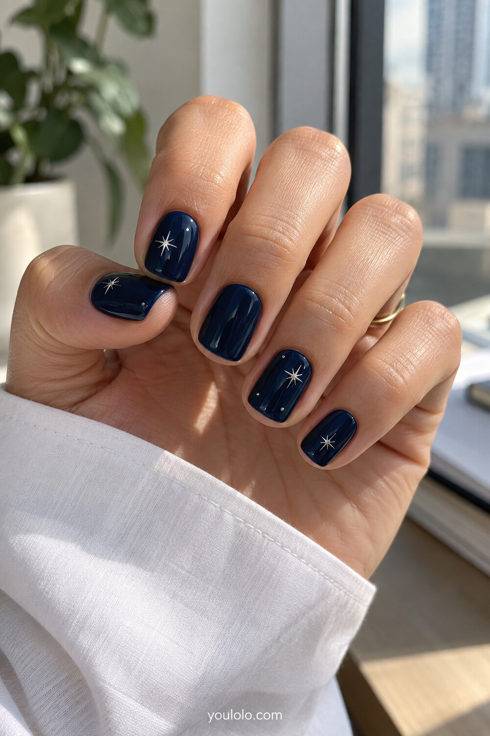 Short navy manicure with sparse hand painted silver micro stars