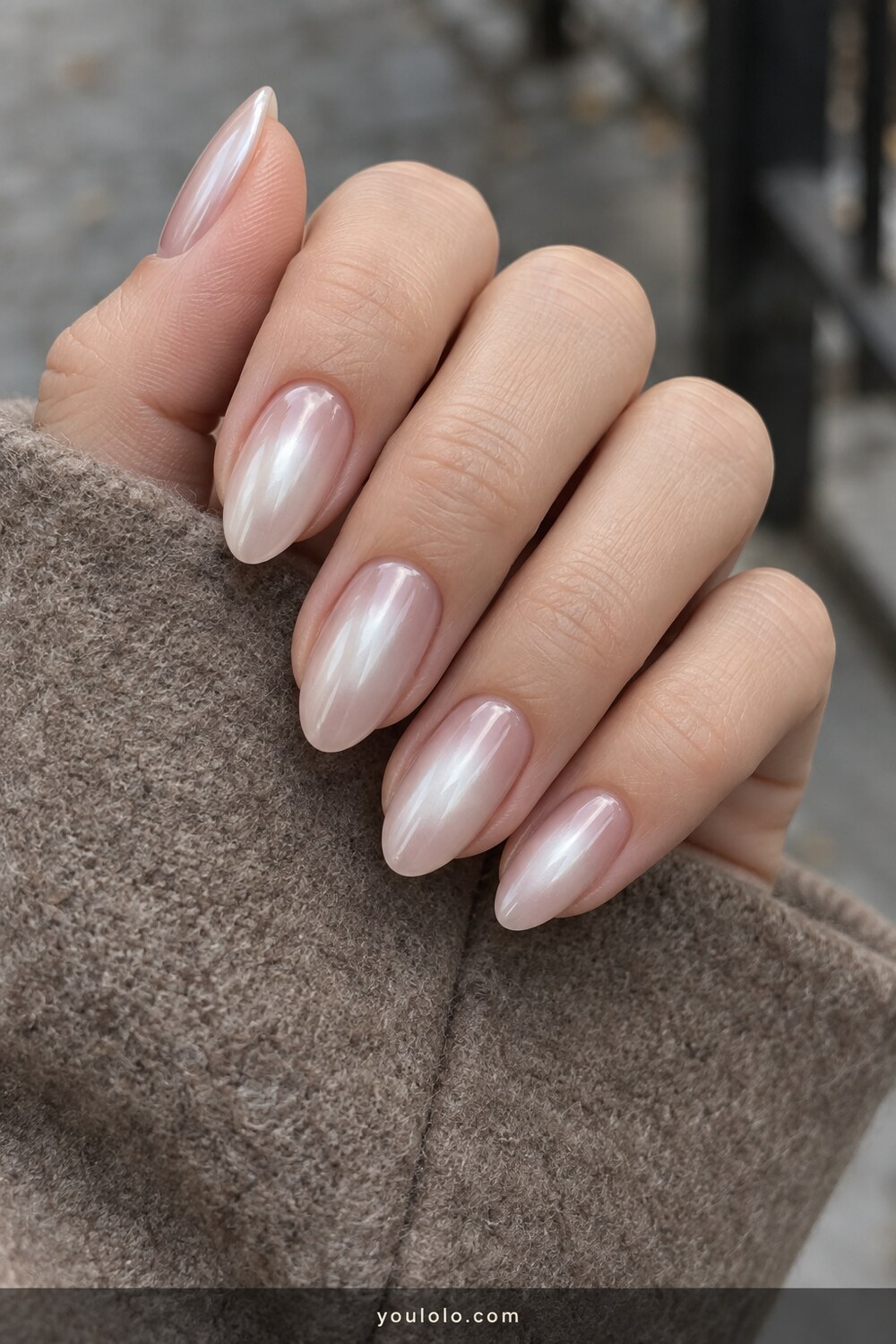 Soft white aura manicure beneath translucent pearl chrome