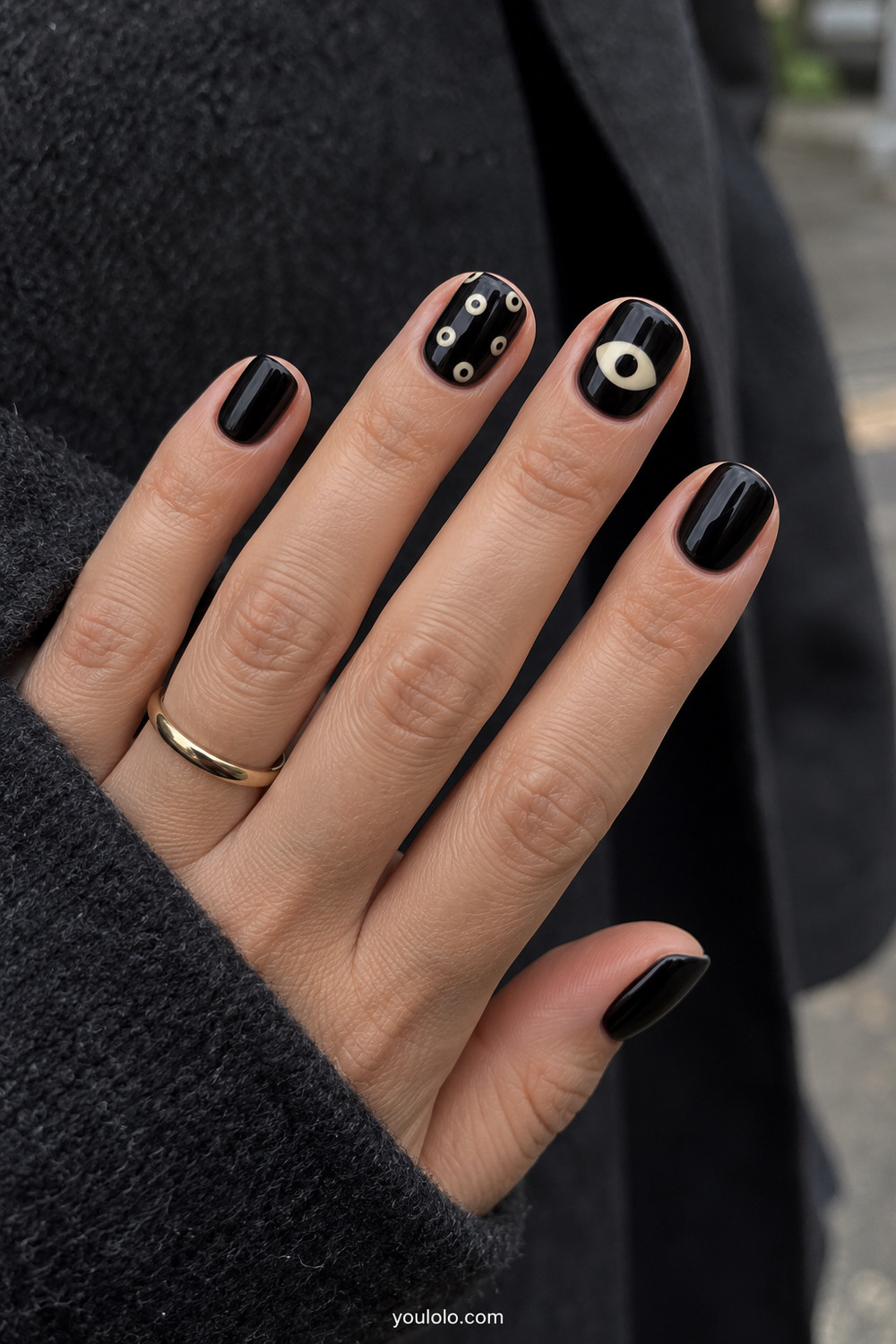Glossy black short nails with minimal cream eye details