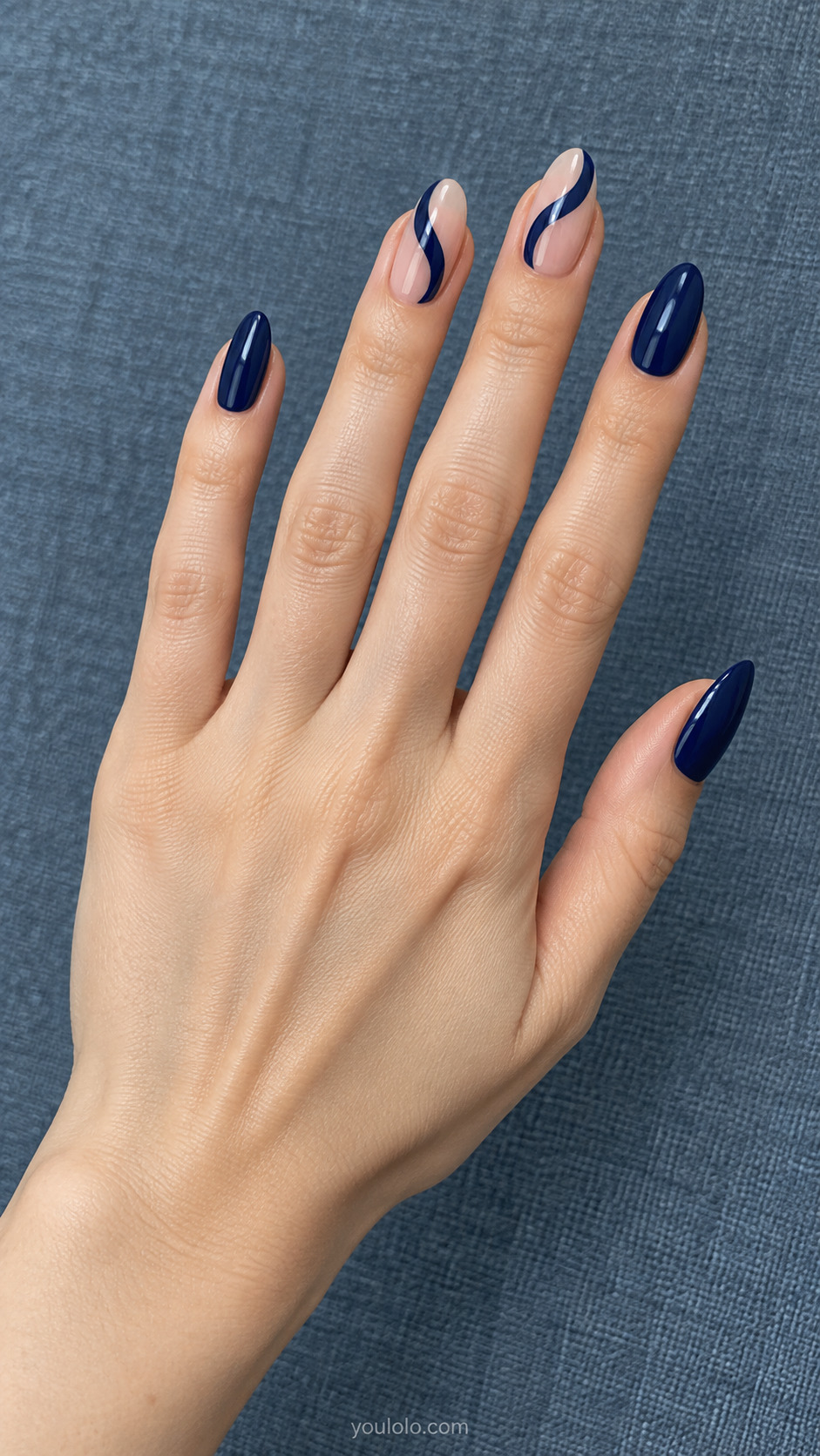 Navy Abstract Waves — Medium almond nails; sheer nude base with two smooth navy curved waves on two accent nails, solid navy other nails.