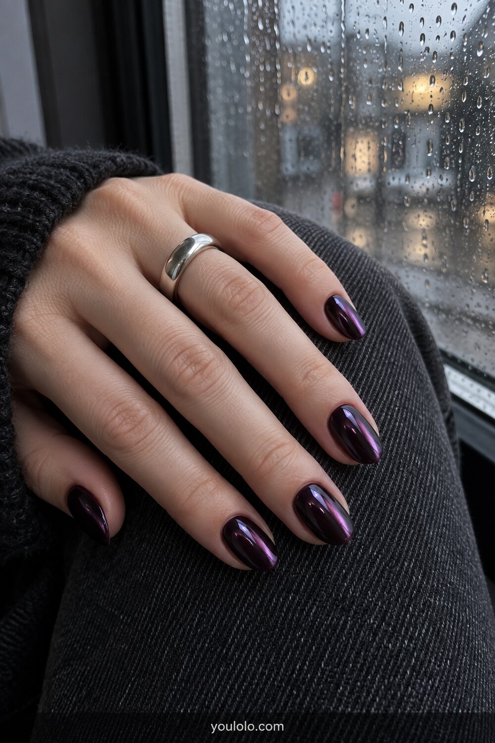 Black plum glass chrome short almond nails by a rainy window