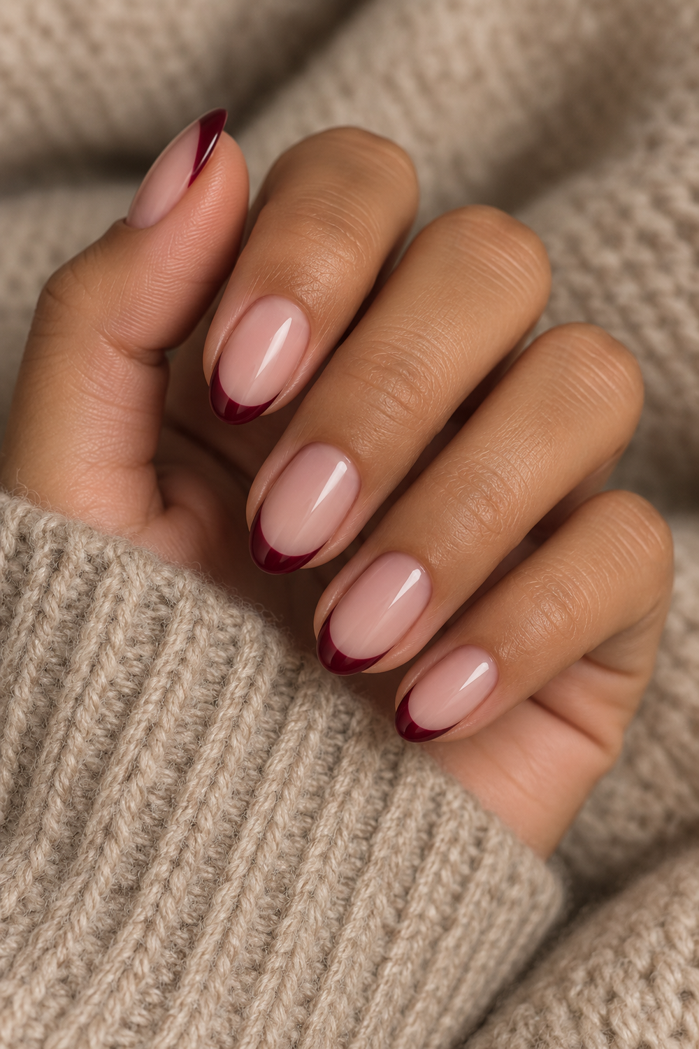 Deep burgundy French tip nails on short almond nails