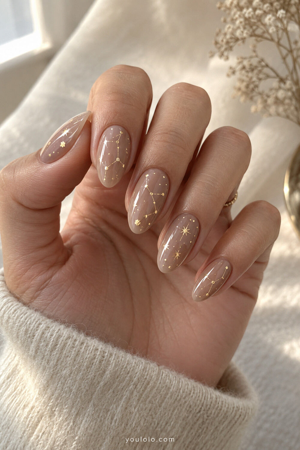 Sheer taupe almond nails with fine gold constellation maps