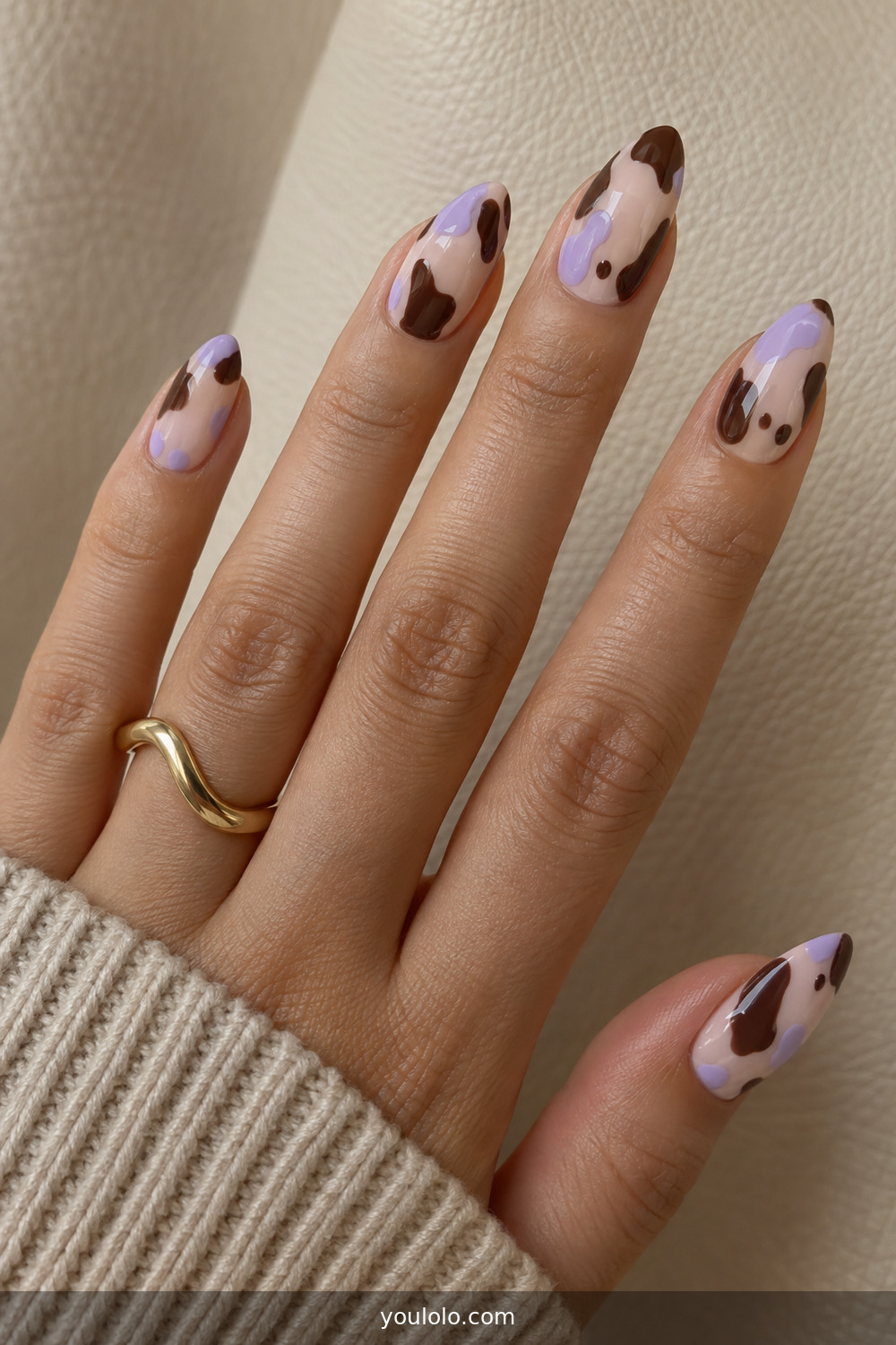 Lavender and brown cow-print patches over milky nails