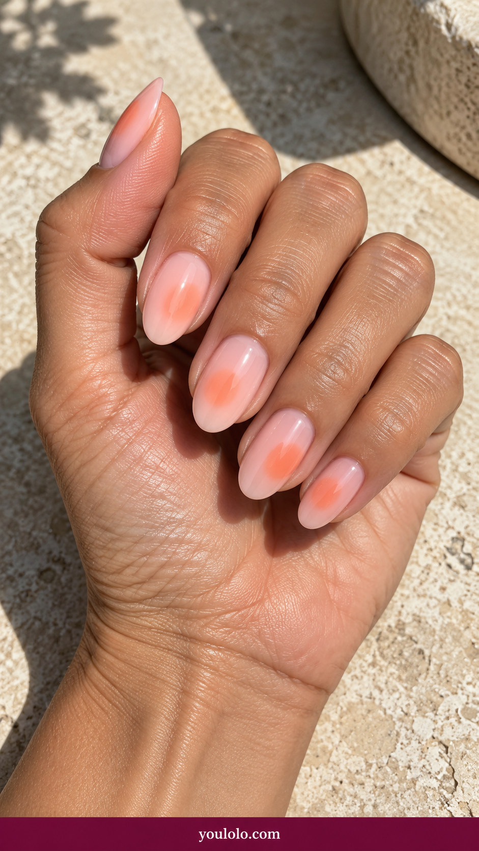 Aura Nails idea 16: pale pink nails with asymmetric apricot aura placed off center on an anatomically realistic feminine hand