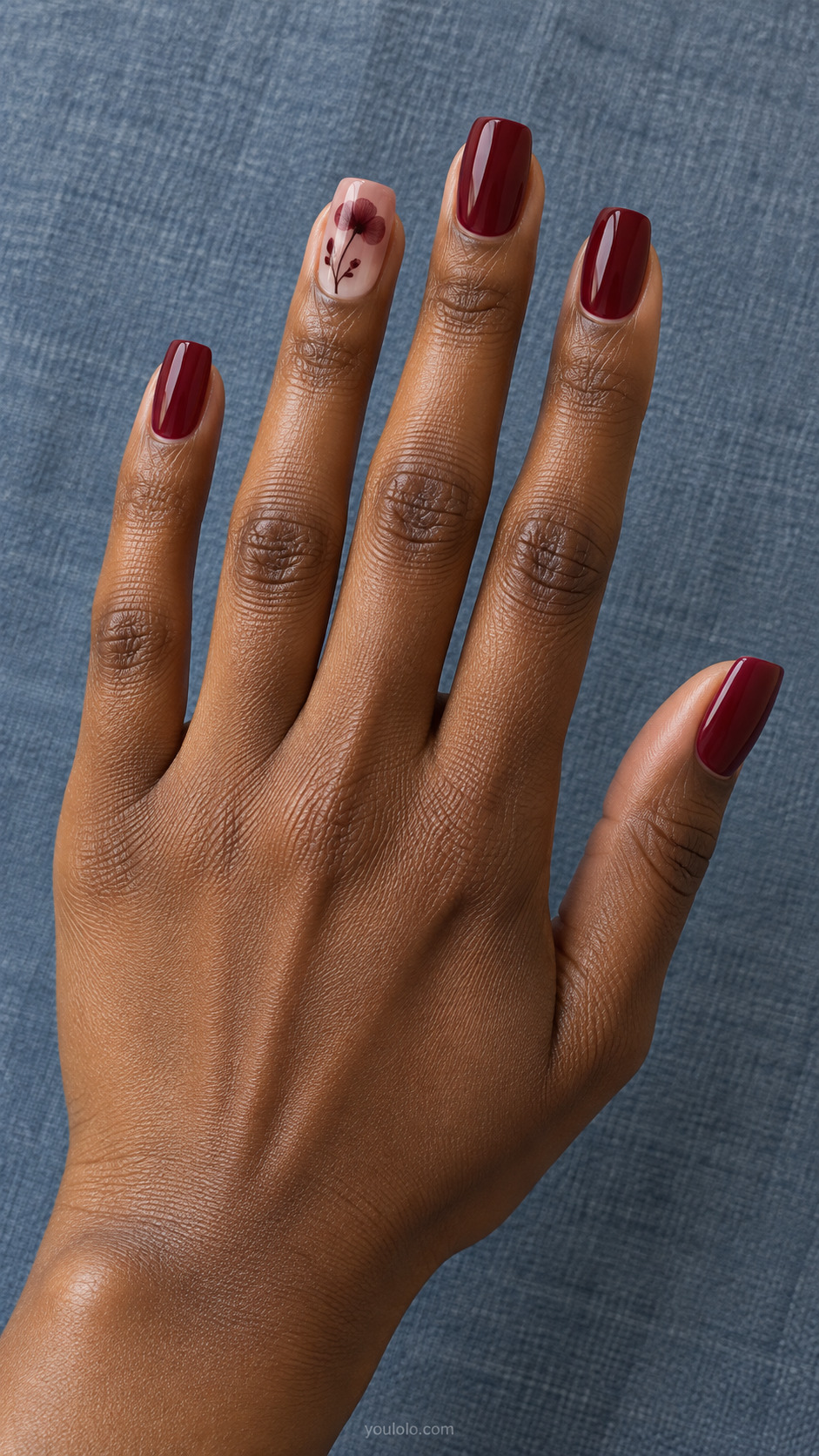 Pressed Flower Silhouette — Medium square nails; translucent nude ring with burgundy flat botanical flower silhouette and fine branching stem, wine others.