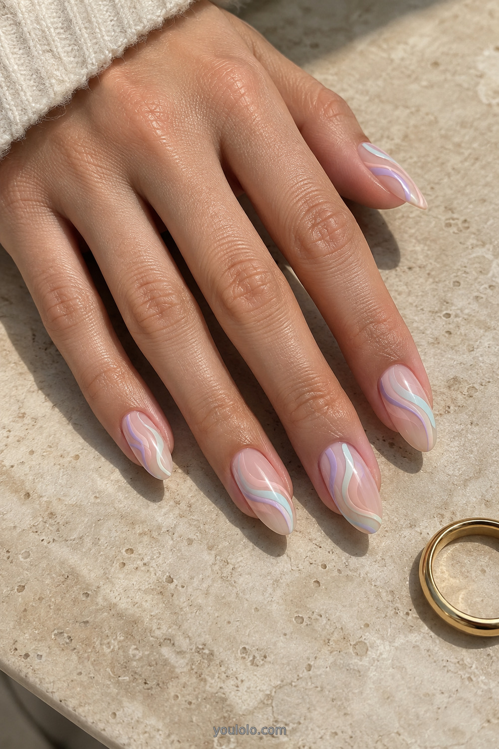Nude almond nails with thin pastel unicorn ribbon swirls