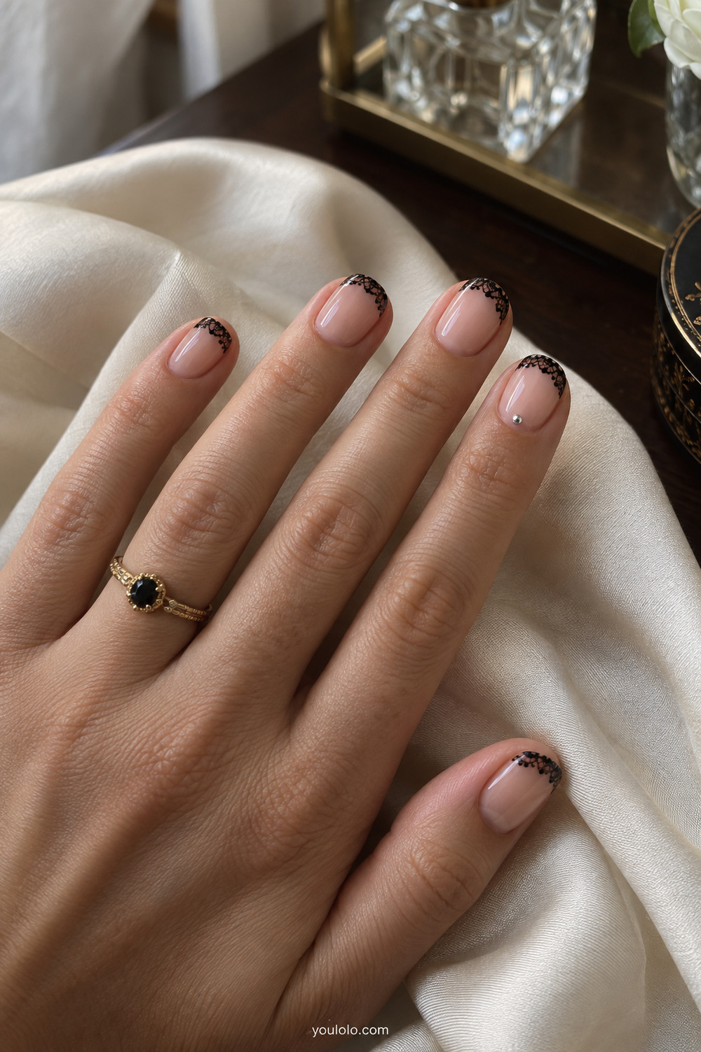 Nude short manicure with fine black gothic lace French tips
