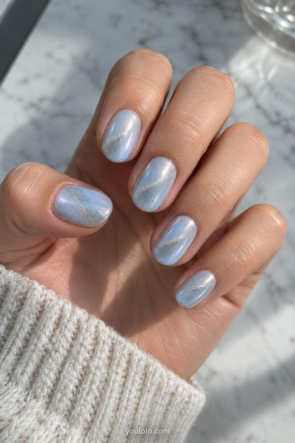 Icy blue pearl nails with a narrow silver magnetic comet streak