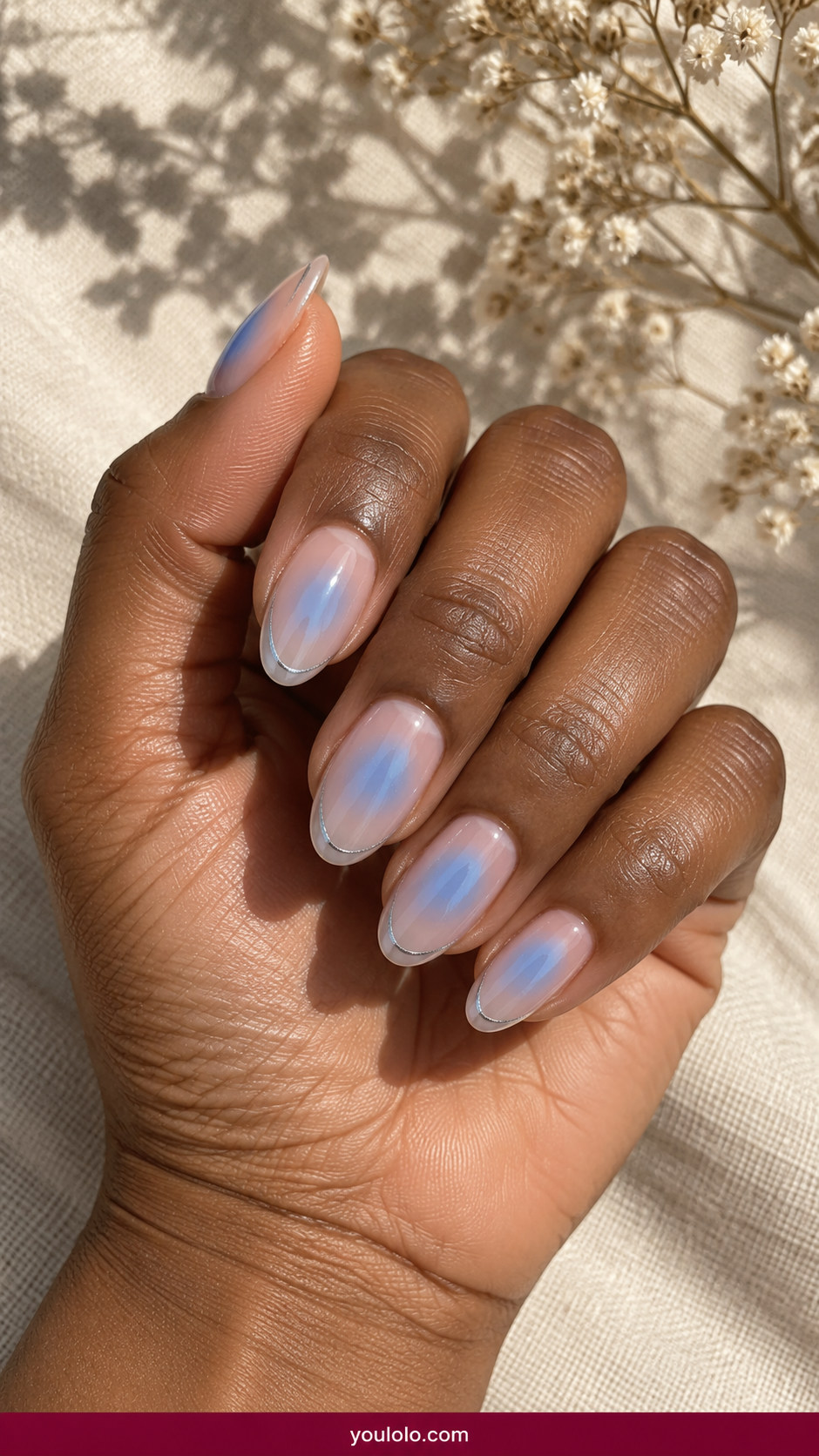 Aura Nails idea 17: medium almond nude nails with icy-blue soft aura and faint silver outline on an anatomically realistic feminine hand