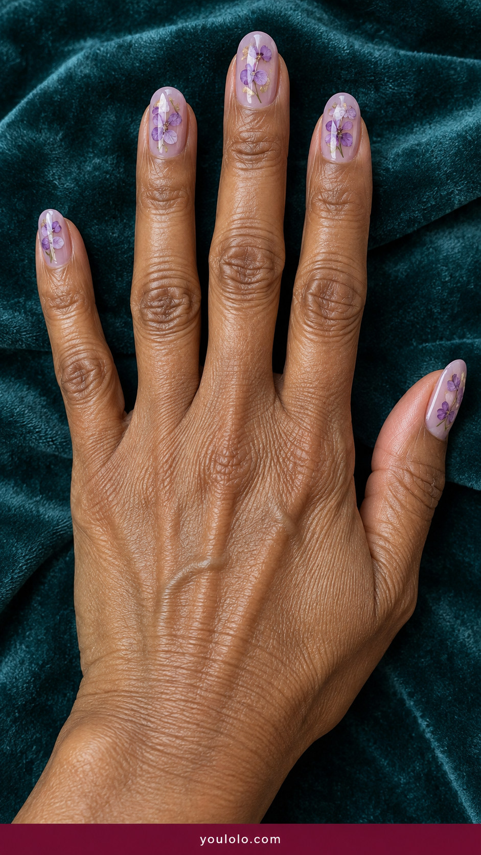 Pressed Flower Nails idea 18: dried lilac flower heads suspended in translucent lavender gel on an anatomically realistic feminine hand
