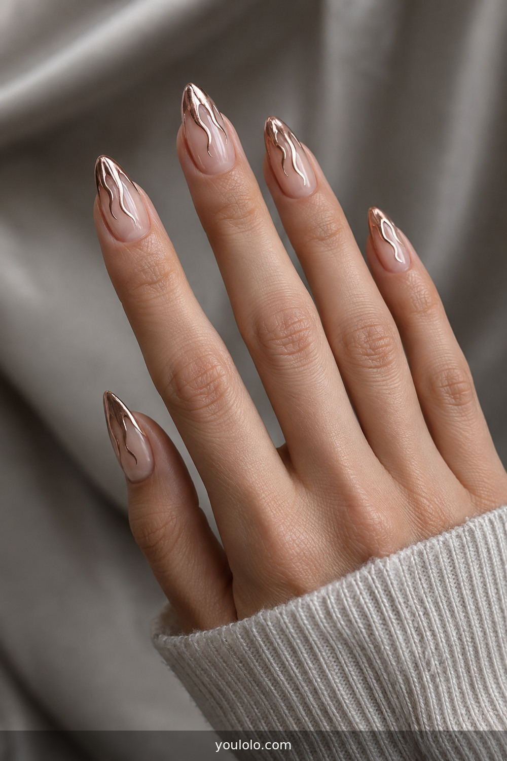 Rose-gold chrome flame tips on nude almond nails
