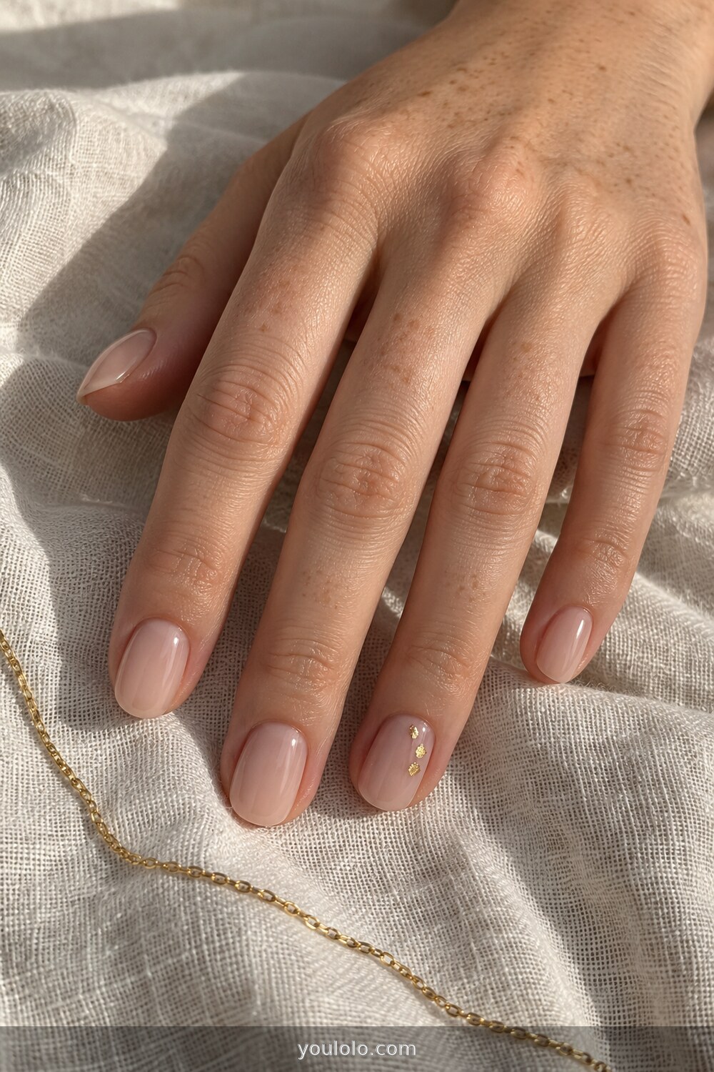 Natural nude nails with a tiny gold leaf accent