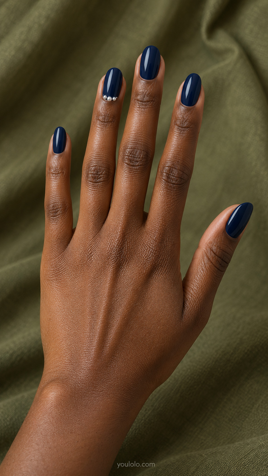 Navy Pearl Crescent — Medium oval nails; glossy navy set with three tiny pearls forming a small arc on ring near base.