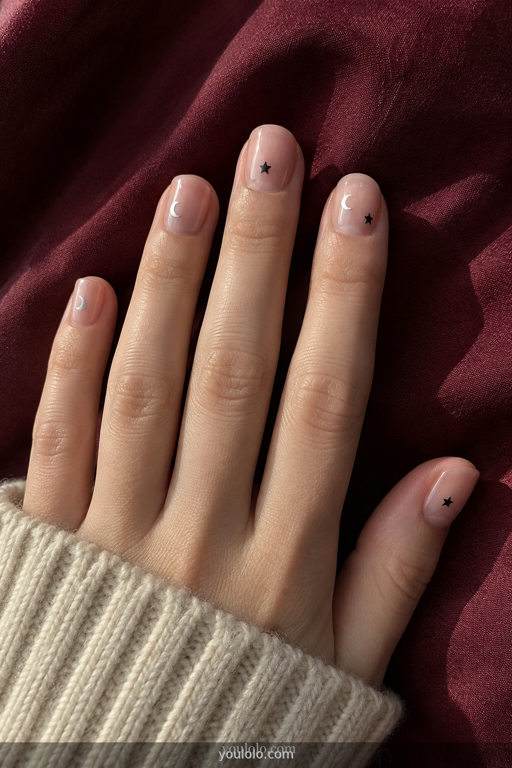 Nude nails with sparse black stars and silver moon stickers