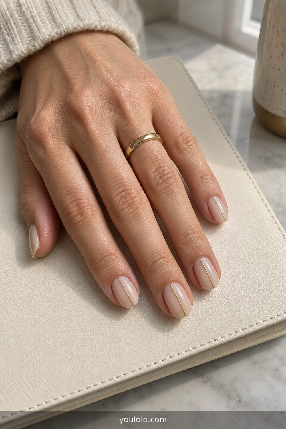 Minimal nude manicure with one fine vertical gold line