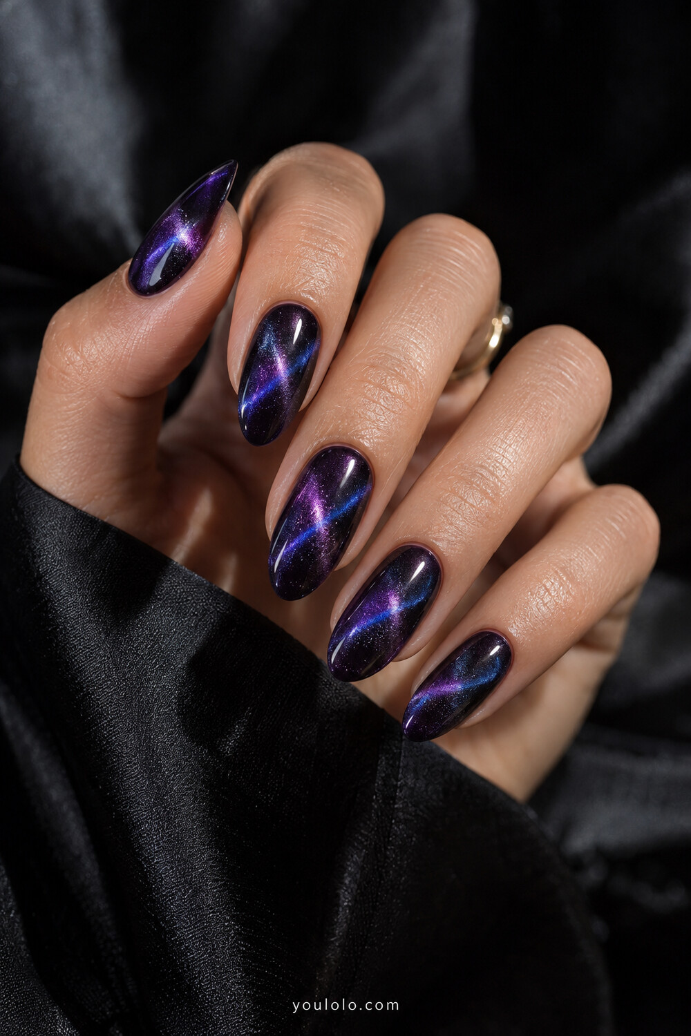 Purple magnetic manicure with two intersecting blue violet light beams