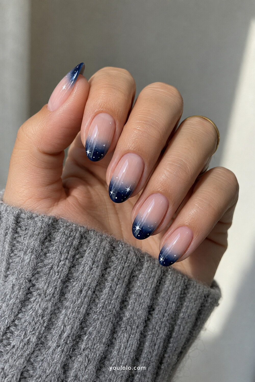 Sheer nude nails with smoky navy gradient tips and tiny stars