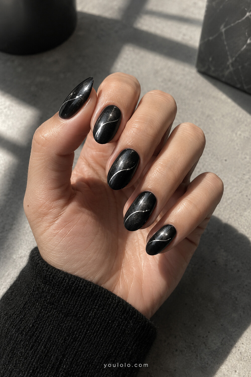 Black chrome almond nails with thin silver orbit curves