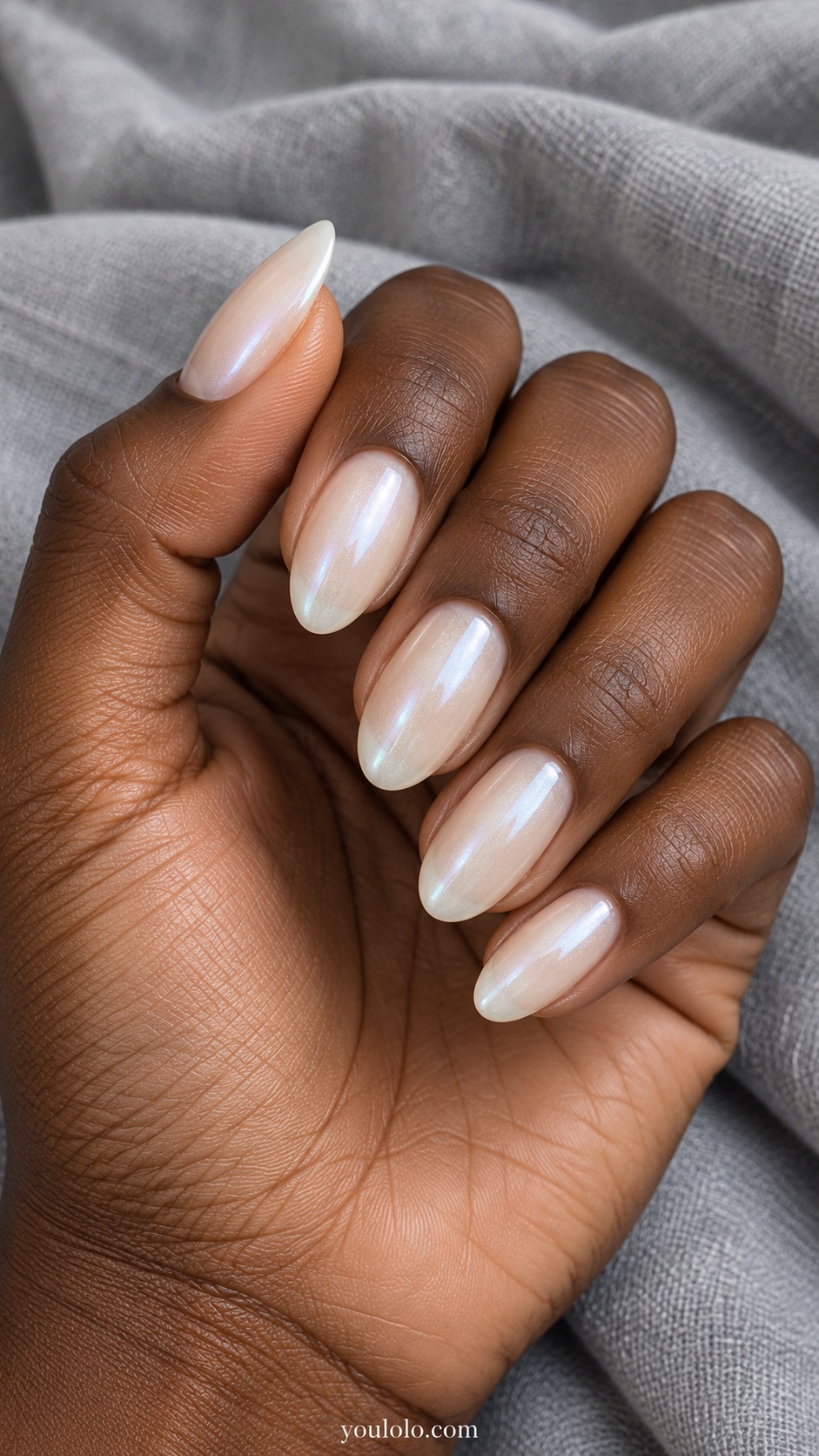 Medium almond nails translucent milky ivory base with a fine silvery white pearlescent glaze, soft luminous reflection, no decorations