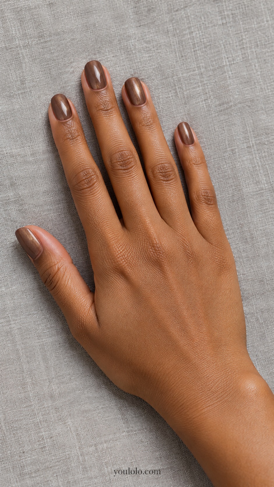 Short oval milk chocolate brown under fine pale golden pearl glaze, no mirror metal