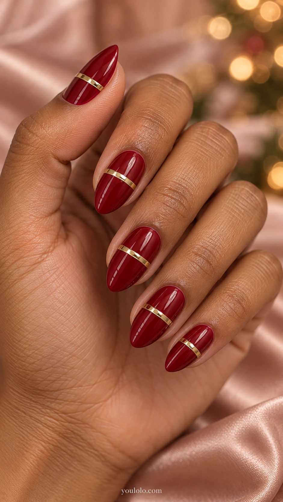 Medium almond deep ruby nails one thin raised-looking gold chrome transverse band across each center no crystals