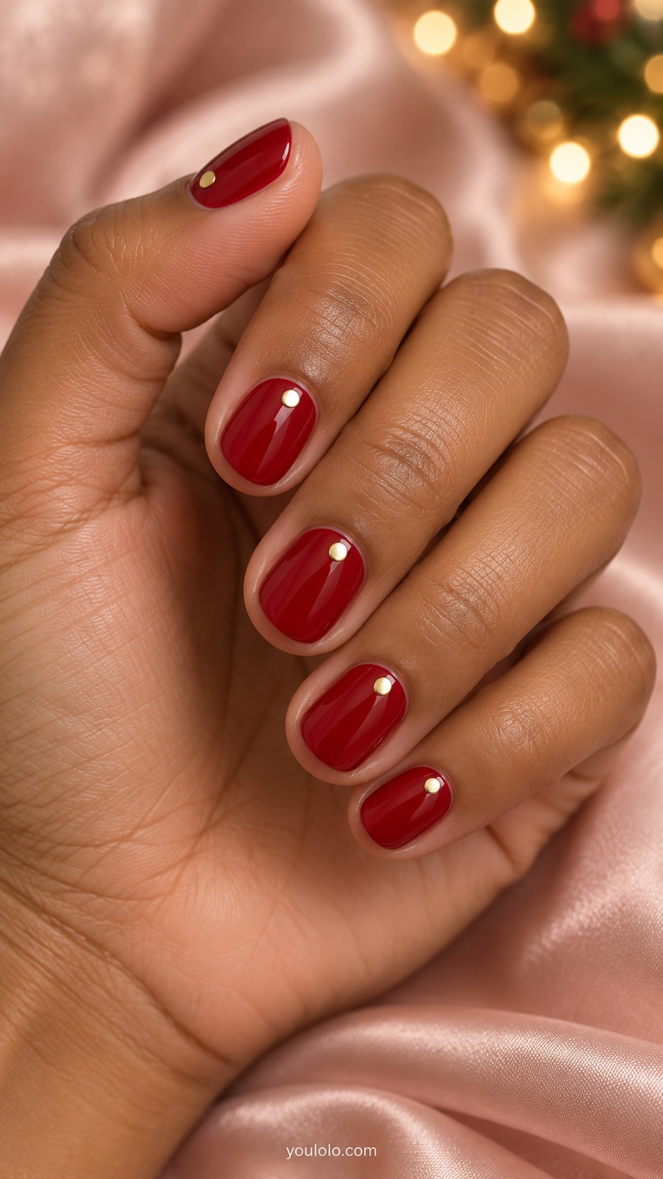 Very short round glossy cherry red nails one small flat gold dot centered near each cuticle