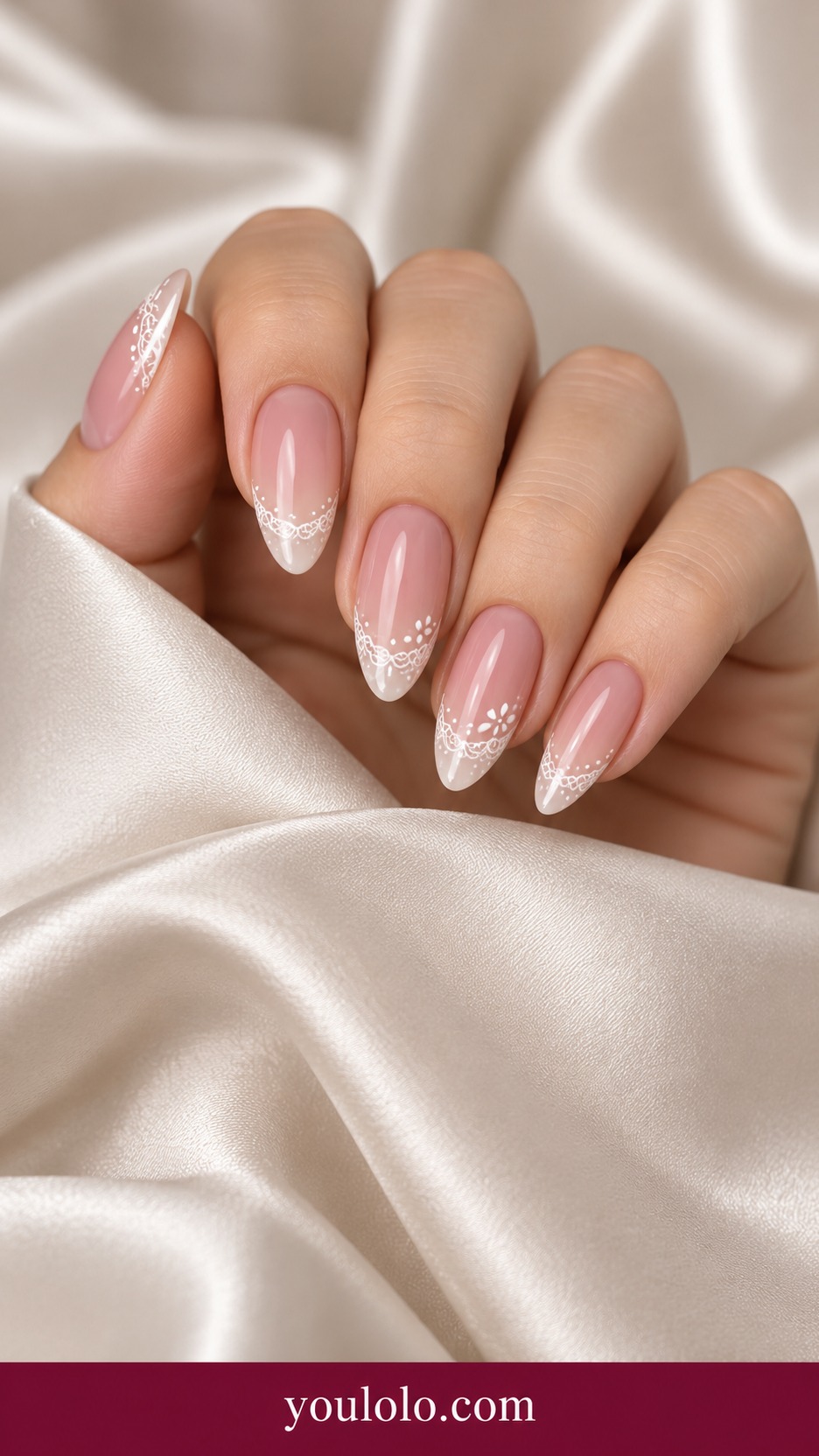 Medium almond blush sheer nails with fine white lace scallops on tips, tiny dotted lace details on two accent nails on a naturally curled young adult hand